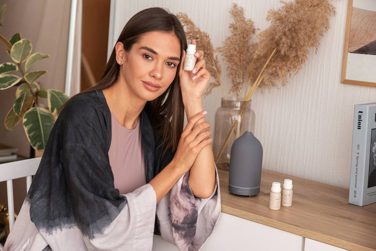 Woman applying tinted facial moisturizer with spf to her cheeks for natural glow